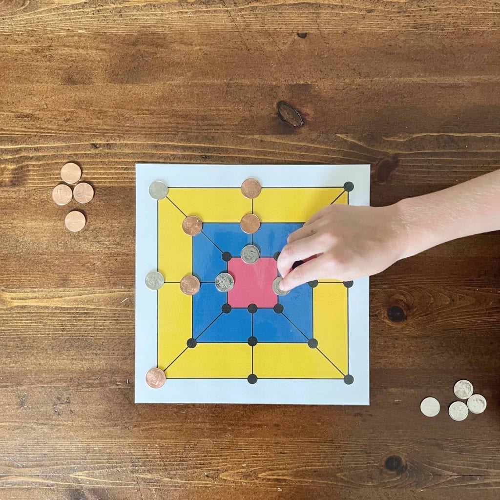 A child sets up the game Trique, a math game from Colombia.