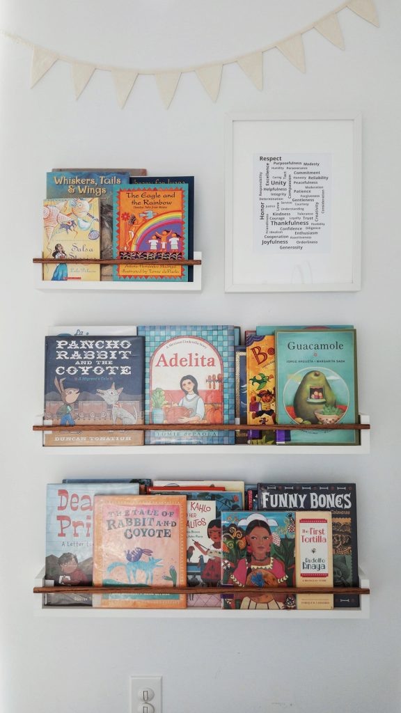 Picture books about Mexico for children displayed on floating picture ledge bookshelves in a homeschool room